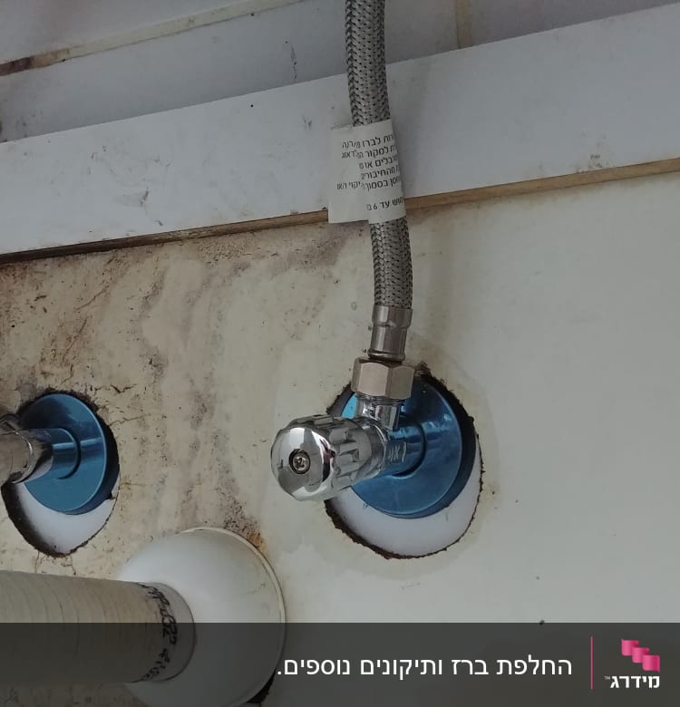 צינורות מים מחוברים לברזים מתכתיים בקיר